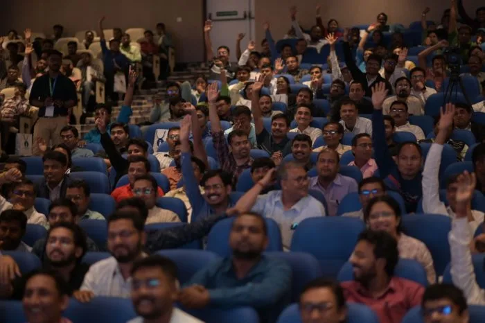 Engaged audience raising hands at a seminar